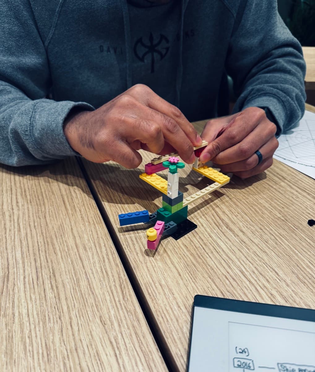 Hands building with LEGO in a Serious Play session — thinking made tangible