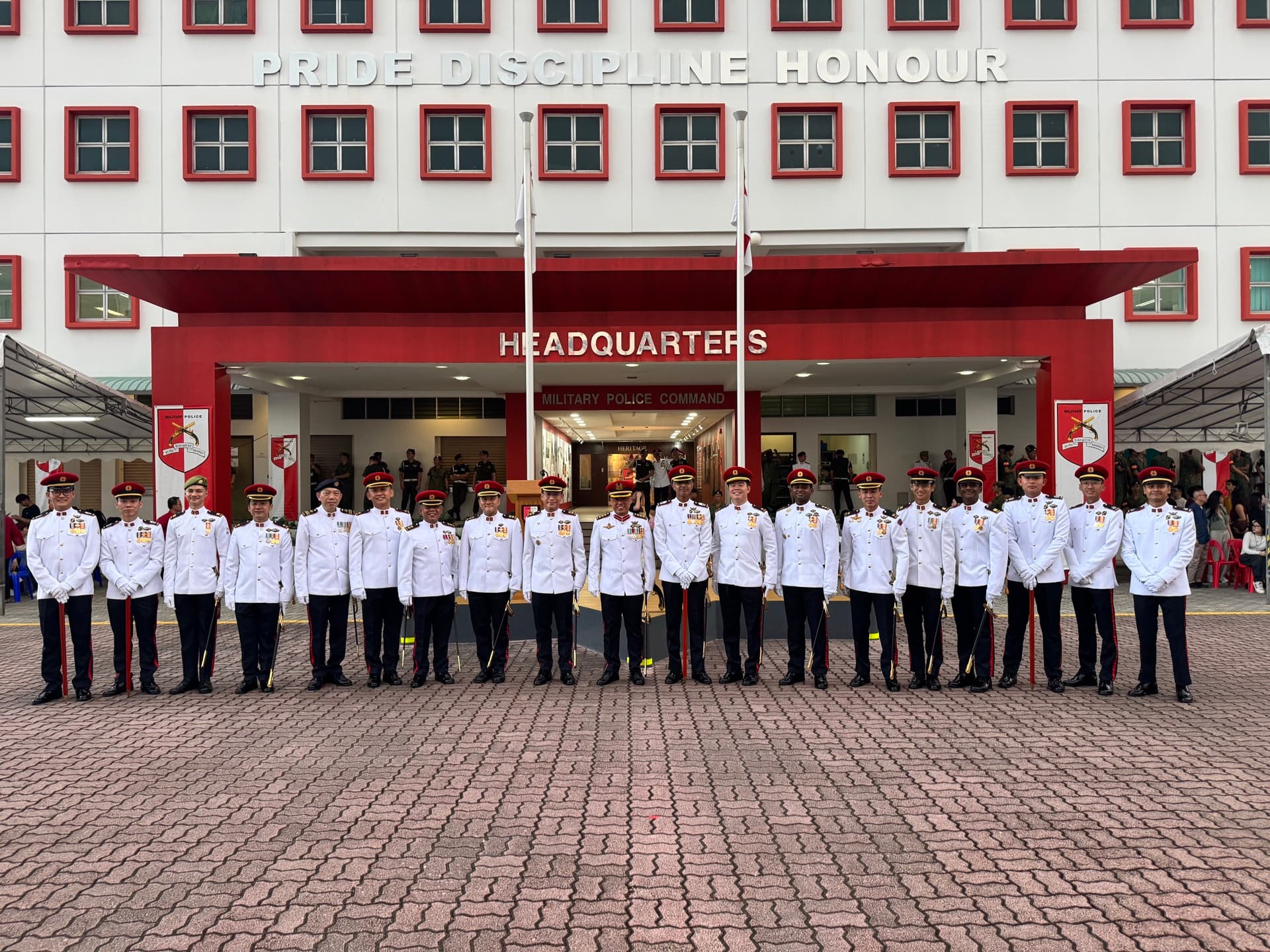 Full military formation in dress whites outside PRIDE DISCIPLINE HONOUR Headquarters