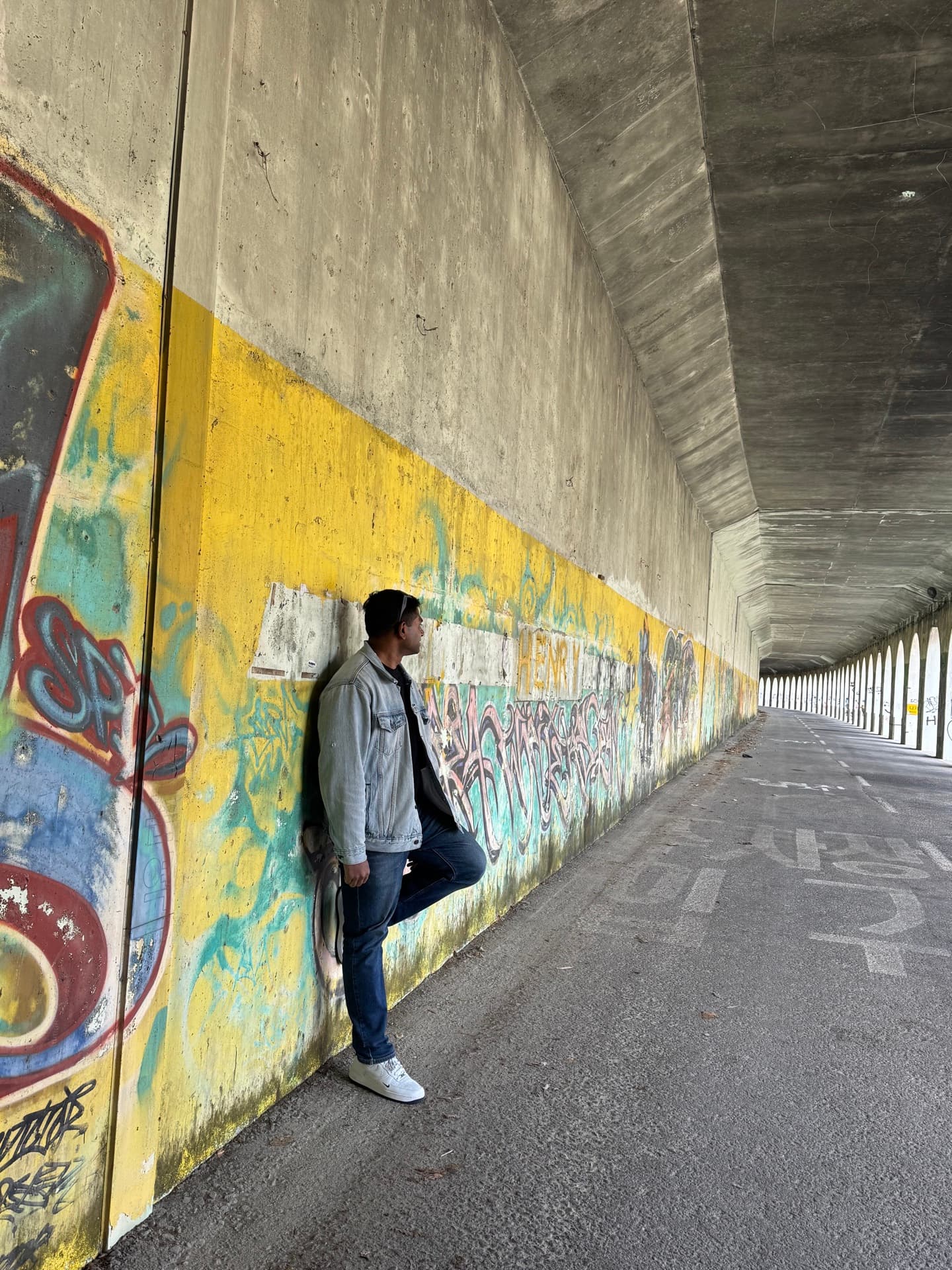 A man alone in a city underpass, mid-thought
