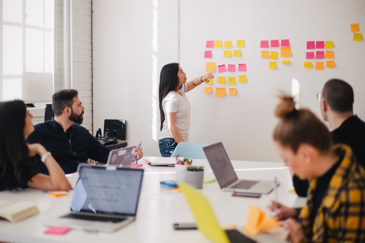 A team working a wall of ideas in a workshop, development at group scale rather than one to one