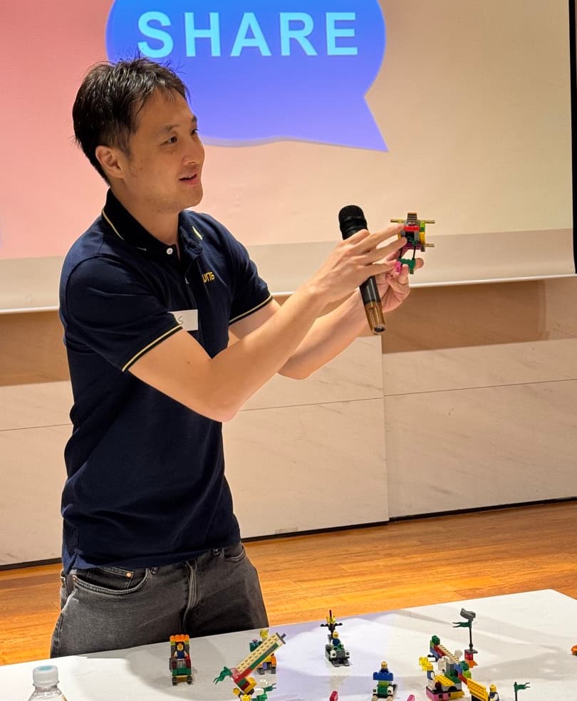 A participant presents his LEGO Serious Play build at the share-out, the step where thinking becomes owned