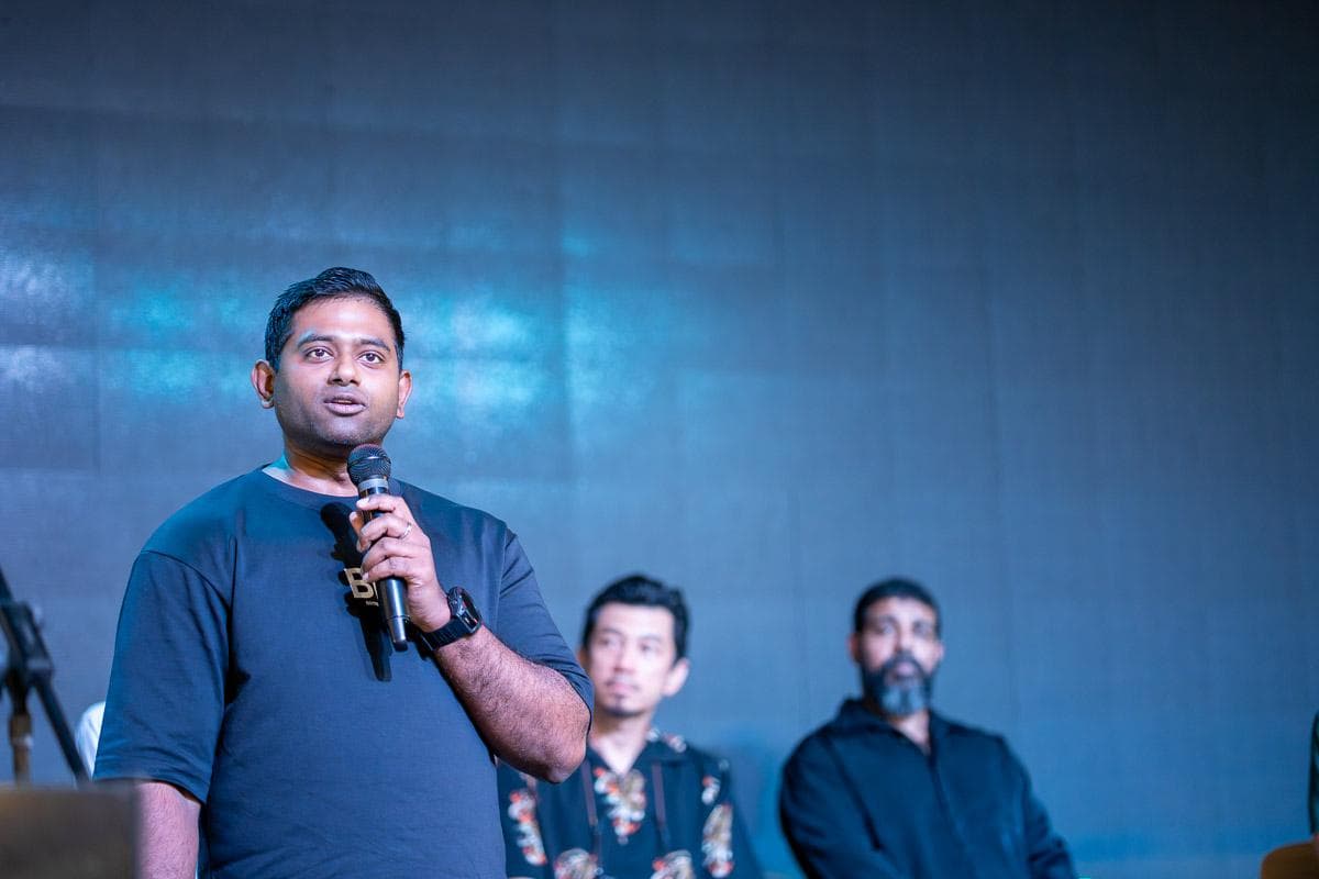 Paul Prathap speaking on stage with a microphone