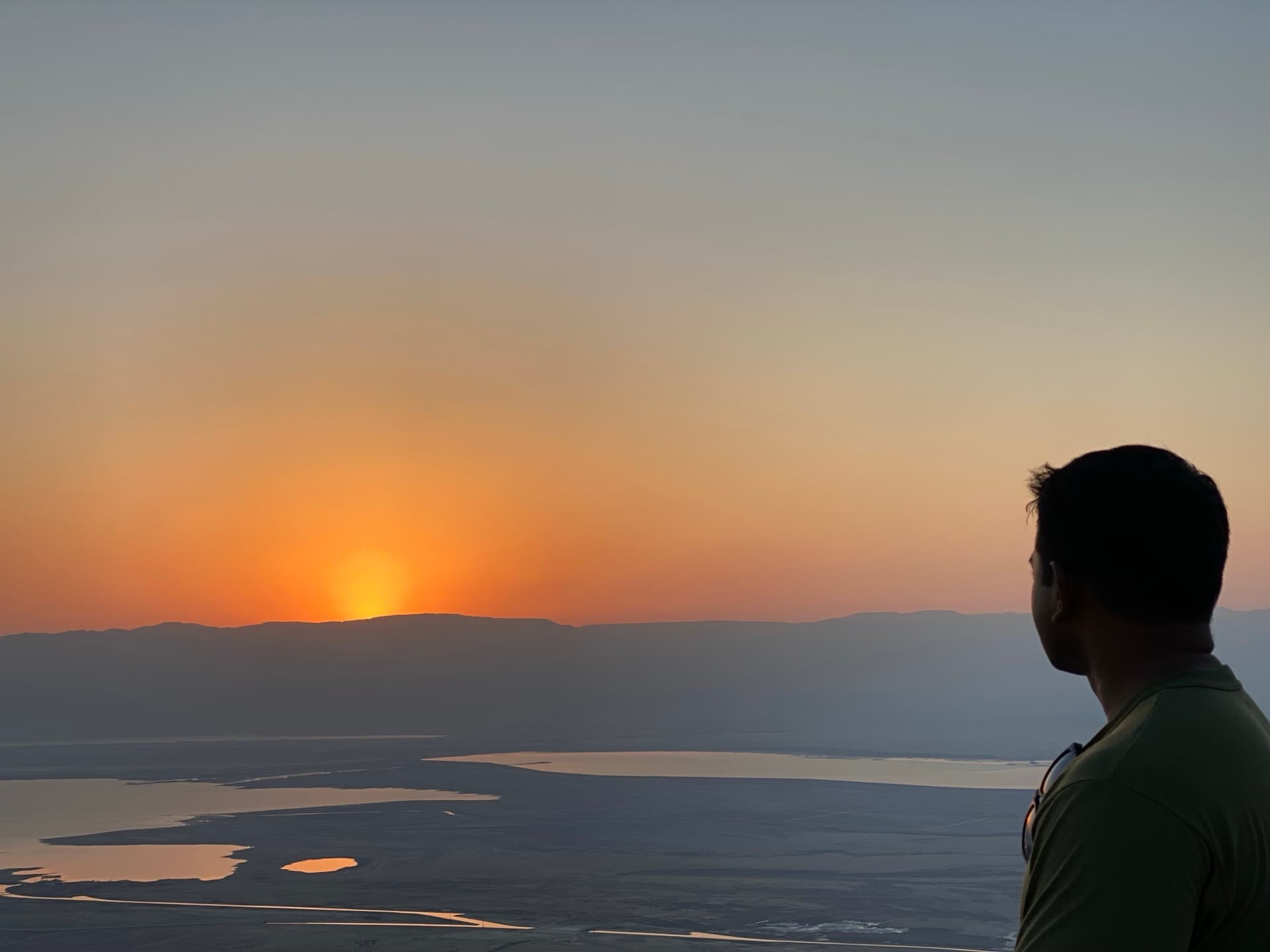 A silhouette on a ridge facing the sunrise, weighing which kind of support to take next